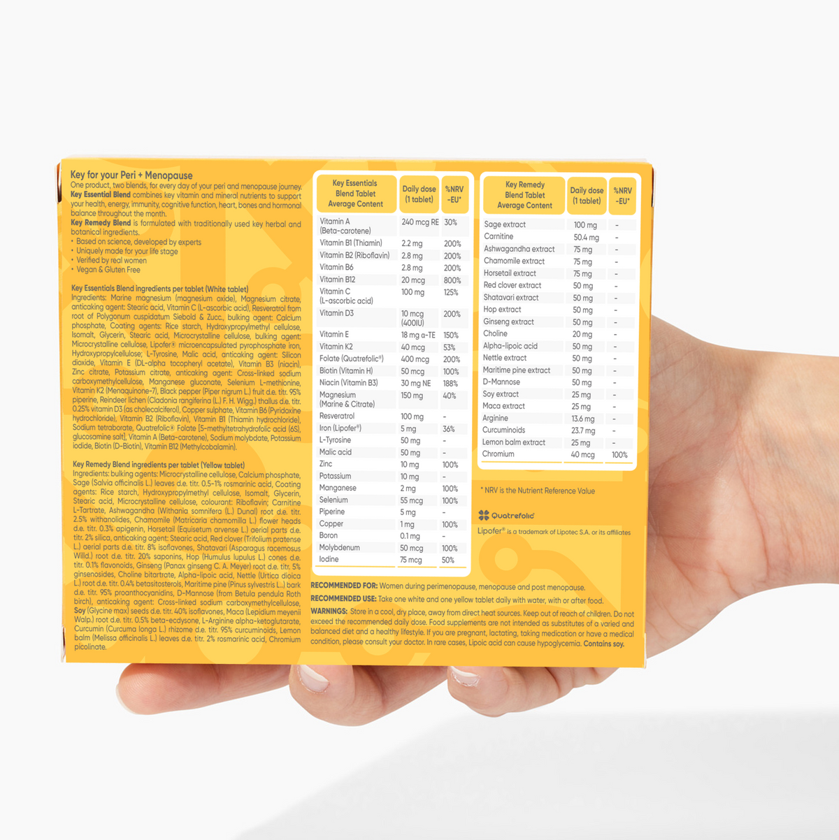 Hand holding a supplement package with detailed nutritional information on a white background
